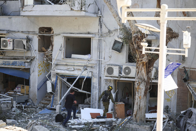 Petugas pertolongan pertama berkumpul di lokasi dampak setelah serangan Iran ke Israel, di tengah konflik Iran-Israel, di Haifa, Israel, Minggu (22/6/2025). Foto: Florion Goga/REUTERS