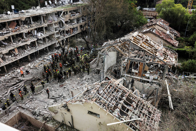 Tim penyelamat dan keamanan bekerja di lokasi bangunan yang hancur setelah serangan rudal dari Iran di Tel Aviv, Israel, Minggu (22/6/2025). Foto: Tomer Appelbaum/REUTERS