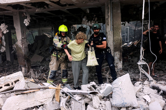 Tim penyelamat mengevakuasi warga setelah serangan rudal dari Iran di Tel Aviv, Israel, Minggu (22/6/2025). Foto: Tomer Appelbaum/REUTERS