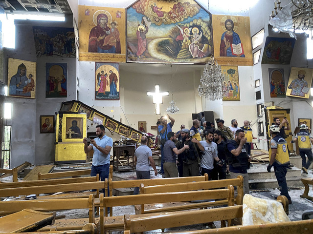 Orang-orang dan anggota pertahanan sipil memeriksa kerusakan setelah ledakan mengguncang Gereja Mar Elias menurut para saksi mata, di lingkungan Dweila, Damaskus, Suriah, Minggu (22/6/2025). Foto: Firas Makdesi/REUTERS