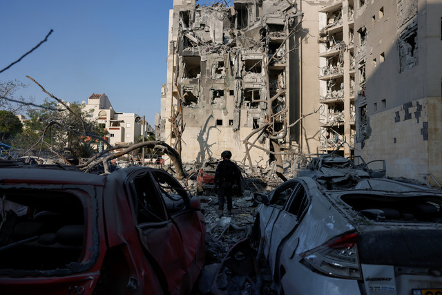 Petugas tanggap darurat melihat kondisi permukiman yang terkena dampak serangan rudal dari Iran di Be'er Sheva, Israel, Selasa (24/6/2025). Foto: Amir Cohen/REUTERS