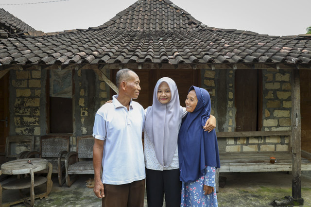 Rofidah Nurhana Lestari (18) bersama kedua orang tuanya. Anak sopir truk jerami di Gunungkidul ini lolos kuliah gratis di UGM. Foto: Dok. UGM