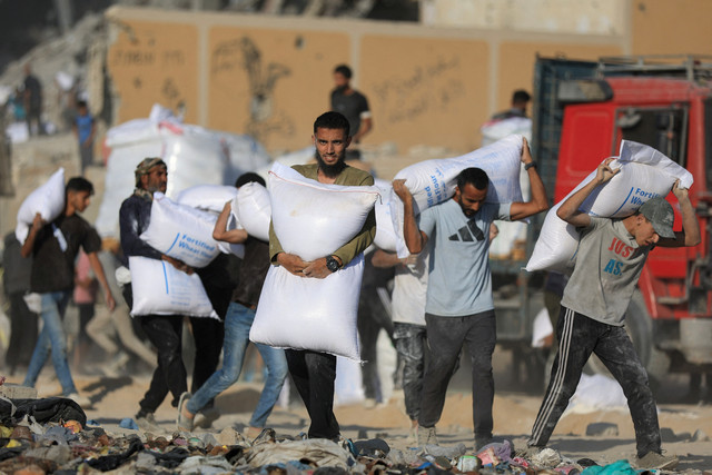 Warga Palestina menerima pasokan bantuan di Beit Lahia, di Jalur Gaza utara, Rabu (25/6/2025). Foto: Dawoud Abu Alkas/REUTERS