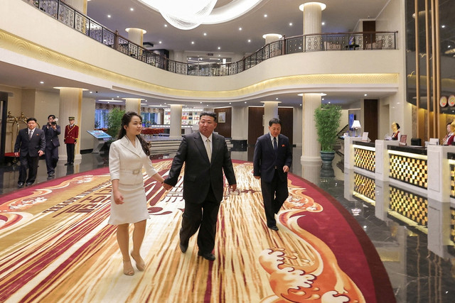 Pemimpin Korea Utara Kim Jong-un bersama putrinya Kim Ju Ae berjalan di dalam hotel selama peresmian  Zona Wisata Pantai Wonsan Kalma, di Wonsan, Korea Utara. Foto: KCNA/via REUTERS