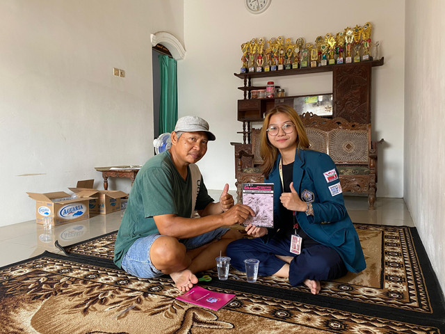 Mahasiswi KKN UNDIP, Fayrishia, tengah memberikan edukasi dan membagikan modul mengenai pemanfaatan temulawak sebagai campuran pakan ikan lele kepada Pak Siswadi, salah satu warga Desa Tambaksari.