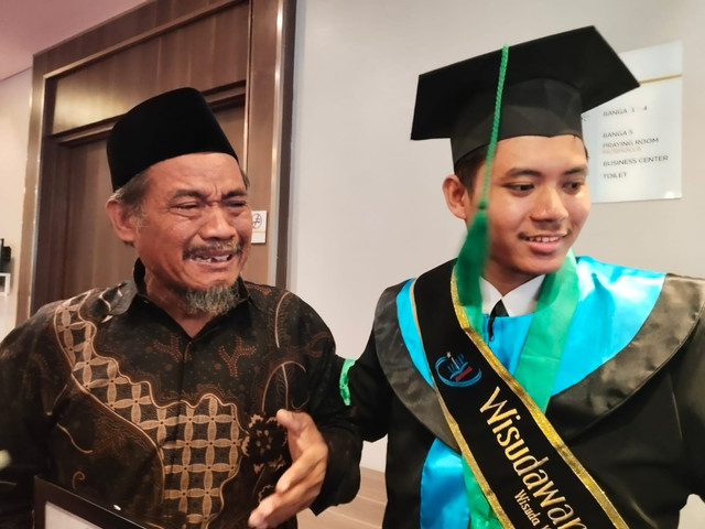 Kaman (kiri) dan anaknya yang lulus cum laude, Karna Januar, Selasa (1/7/2025). Dok: kumparan