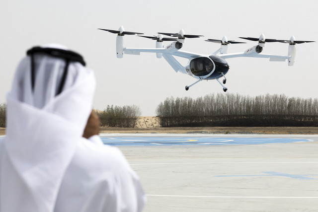 Seorang pria mengenakan pakaian tradisional Emirat merekam pesawat eksperimental Joby Dubai Aerial Taxi yang lepas landas di Dubai, Uni Emirat Arab, Senin (30/6/2025). Foto: Amr Alfiky/REUTERS