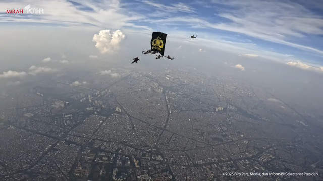 Bendera Tribrata berkibar di angkasa oleh para penerjun saat HUT ke-79 Bhayangkara di Kawasan Monumen Nasional (Monas), Jakarta, Selasa (1/7/2025). Foto: YouTube/Sekretariat Presiden