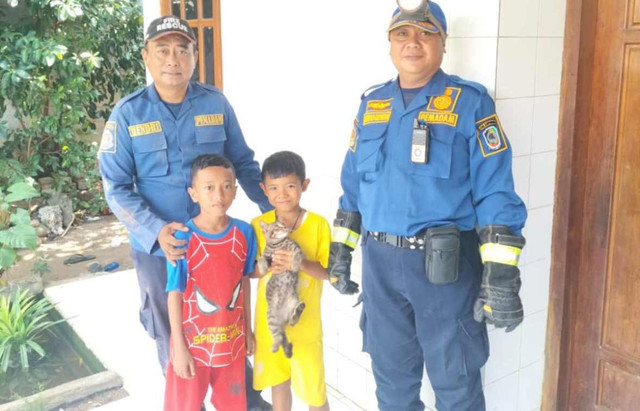 Damkar Banyuwangi bersama kucing peliharaan yang diselamatkannya. Dok: Damkar Banyuwangi