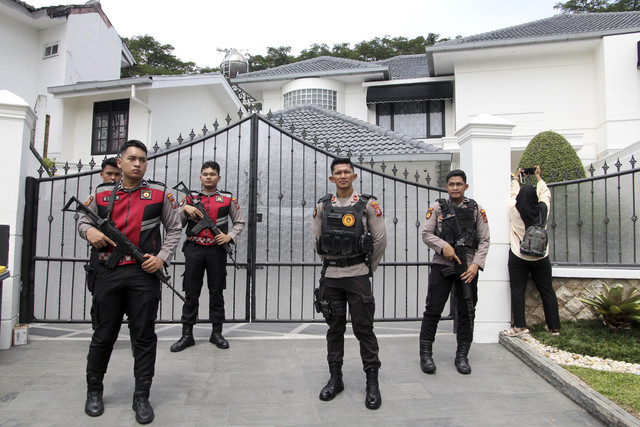 Polisi berjaga di gerbang rumah saat penyidik KPK melakukan penggeledahan terkait kasus dugaan korupsi proyek pembangunan jalan di rumah pribadi Kepala Dinas PUPR Provinsi Sumatera Utara Topan Obaja Putra Ginting di Medan, Sumatera Utara, Rabu (2/7). Foto: Yudi Manar/ ANTARA FOTO