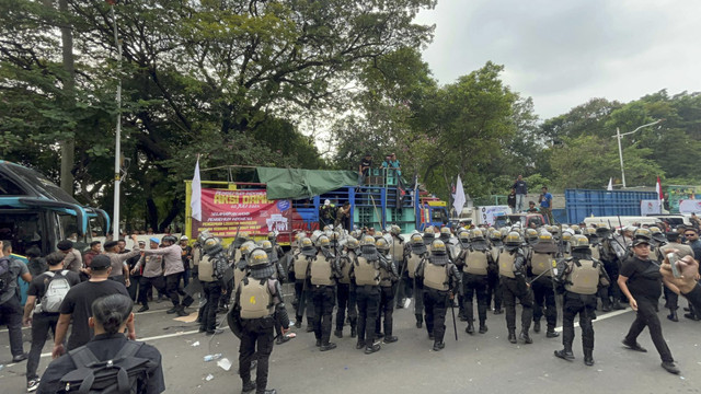 Sejumlah petugas kepolisian berjaga saat demo supir truk tolak peraturan ODOL ke pemerintah di Jalan Merdeka Selatan, Jakarta, Rabu (2/7/2025). Foto: Rayyan Farhansyah/kumparan