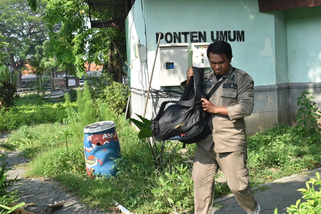 Petugas Satpol PP Surabaya membersihkan perabot milik warga yang tersimpan di toilet umum Taman Lumumba. Foto: Diskominfo Surabaya