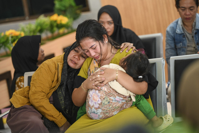 Keluarga korban menangis saat menanti kabar pencarian korban KMP Tunu Pratama Jaya yang tenggelam di Selat Bali di Posko pengaduan Pelabuhan Ketapang, Banyuwangi, Jawa Timur, Kamis (3/7/2025). Foto: Stringer/AFP