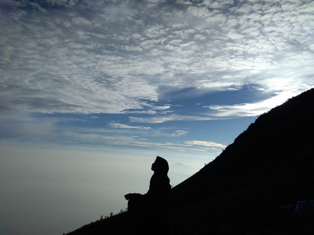 IIustrasi: Seseorang duduk di puncak gunung memandang langit (Foto: Unsplash, bebas hak cipta)
