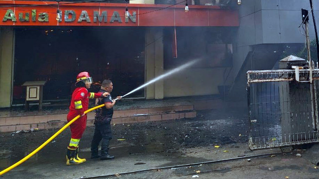 Petugas pemadam kebakaran Kota Manado saat memadamkan api yang membakar Aula Idaman, Jumat (4/7). 