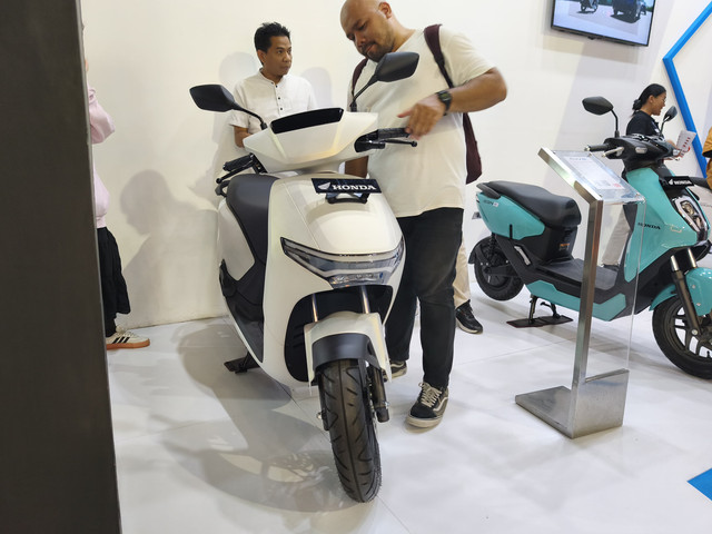 Pengunjung Pekan Raya Jakarta (Jakarta Fair) melihat lini motor listrik di booth Honda. Foto: Sena Pratama/kumparan