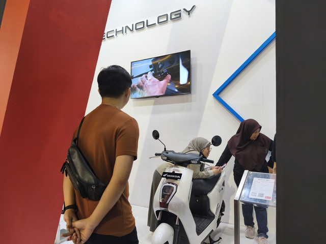Pengunjung Pekan Raya Jakarta (Jakarta Fair) melihat lini motor listrik di booth Honda. Foto: Sena Pratama/kumparan