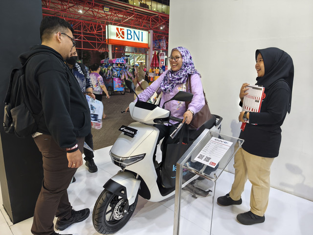Pengunjung Pekan Raya Jakarta (Jakarta Fair) melihat lini motor listrik di booth Honda. Foto: Sena Pratama/kumparan