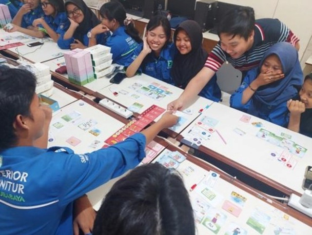 Mahasiswa ITS ketika memeragakan bermain Tata Harta bersama para siswa SMKN 12 Surabaya. Foto: Humas ITS