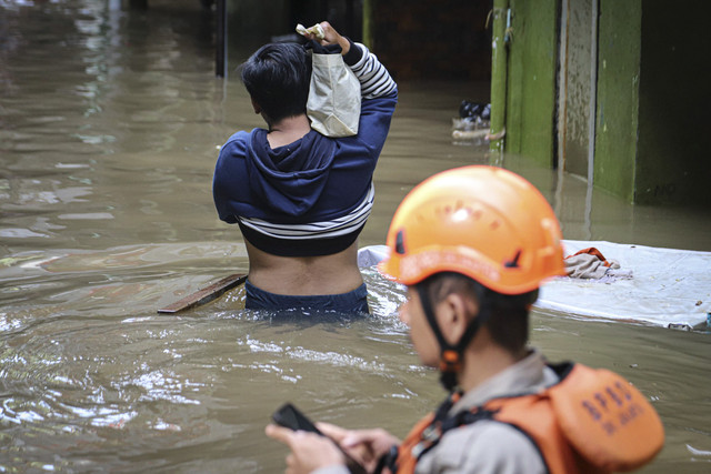 Sejumlah warga beraktivitas di tengah banjir yang melanda pemukiman padat penduduk di kawasan Kebon Pala, Kampung Melayu, Jakarta, Selasa (8/7/2025). Foto: Iqbal Firdaus/kumparan