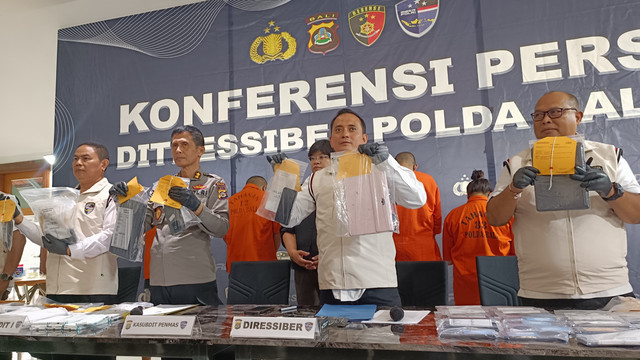 Dirresiber Polda Bali Kombes Ranefli Dian Chandra (kedua dari kanan) menunjukkan barang bukti kasus penipuan data pribadi untuk judol di Polda Bali, Rabu (9/7/2025). Foto: Denita BR Matondang/kumparan