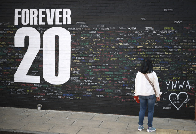 Seorang warga menuliskan pesan-pesan untuk mengenang kematian pemain sepak bola Liverpool Diogo Jota di kawasan sekitar Stadion Anfield, Liverpool, Rabu (9/7/2025). Foto: Phil Noble/Reuters