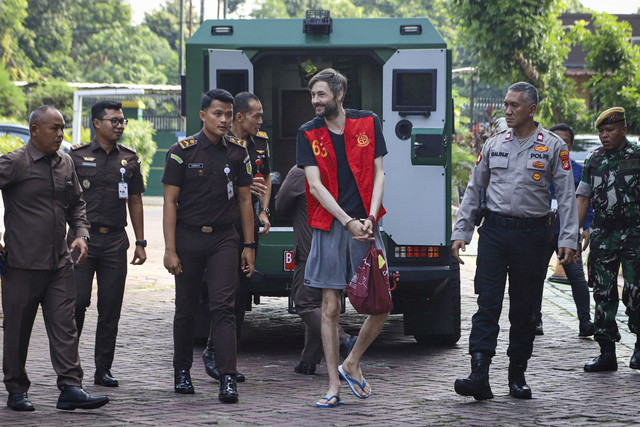 Warga negara (WN) Rusia Aleksandr Vladimirovich Zverev berjalan keluar dari mobil tahanan saat tiba di Kantor Kejaksaan Negeri Jakarta Selatan, Jakarta, Kamis (10/7/2025). Foto: Iqbal Firdaus/kumparan