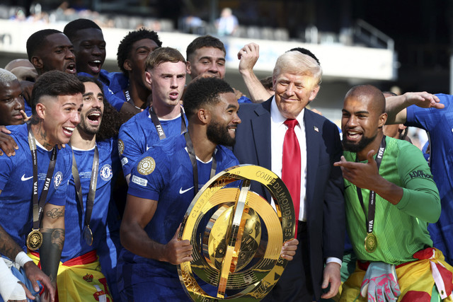Pemain Chelsea Reece James memegang trofi saat merayakannya bersama rekan setimnya dan didampingi Presiden AS Donald Trump setelah menjuarai Piala Dunia Antarklub di Stadion MetLife, East Rutherford, New Jersey, A.S, Minggu (13/7/2025). Foto: Kevin Lamarque/REUTERS