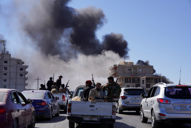 Asap mengepul dari sebuah gedung, saat pasukan Suriah memasuki kota Sweida setelah bentrokan selama dua hari di Sweida, Suriah, Selasa (15/7/2025). Foto: Karam al-Masri/ REUTERS