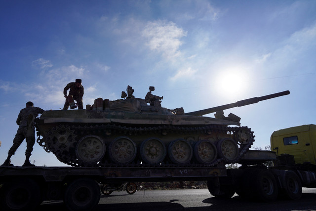 Anggota pasukan keamanan Suriah berdiri di atas kendaraan militer setelah pasukan Suriah memasuki kota Sweida setelah bentrokan selama dua hari di Sweida, Suriah, Selasa (15/7/2025). Foto: Karam al-Masri/ REUTERS