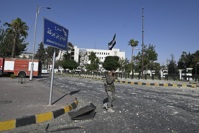 Anggota pasukan keamanan Suriah berjaga setelah serangan Israel ke markas tentara dan kementerian pertahanan Suriah di Damaskus, Suriah, Rabu (16/7/2025). Foto: Louai Beshara/AFP