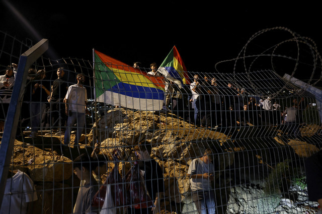 Sejumlah warga membawa bendera Druze saat konflik berlangsung di Suriah, Rabu (16/7/2025). Foto: Ammar Awad/Reuters
