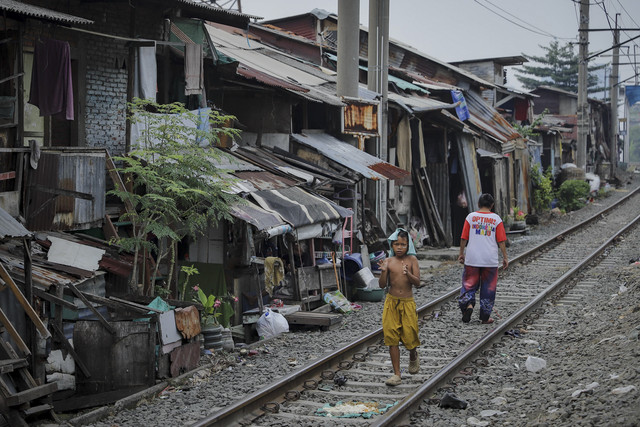 Dua warga beraktivitas di rel kereta api di kawasan Pejompongan, Jakarta, Kamis (16/7/2025). Foto: Jamal Ramadhan/kumparan