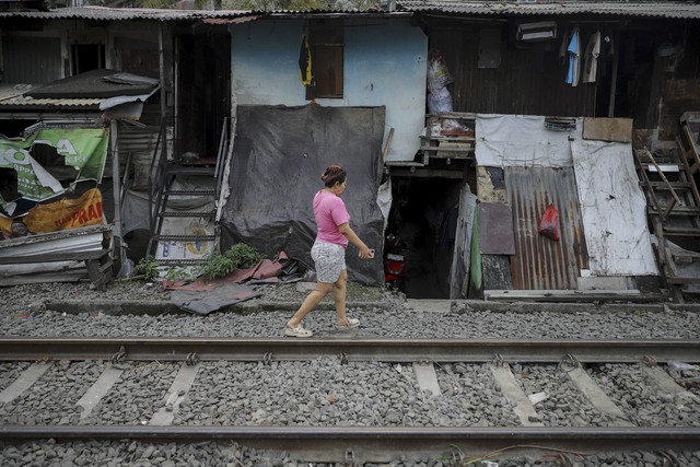 Seorang warga beraktivitas di rel kereta api di kawasan Pejompongan, Jakarta, Kamis (16/7/2025). Foto: Jamal Ramadhan/kumparan