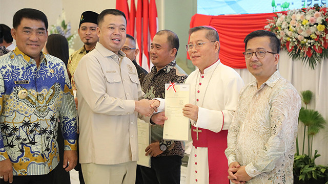 Menteri ATR/BPN, Nusron Wahid, didampingi Gubernur Sulawesi Utara, Yulius Selvanus, menyerahkan sertifikat tanah milik rumah ibadah ke Uskup Manado Rolly Untu, di Manado, Kamis (17/7).