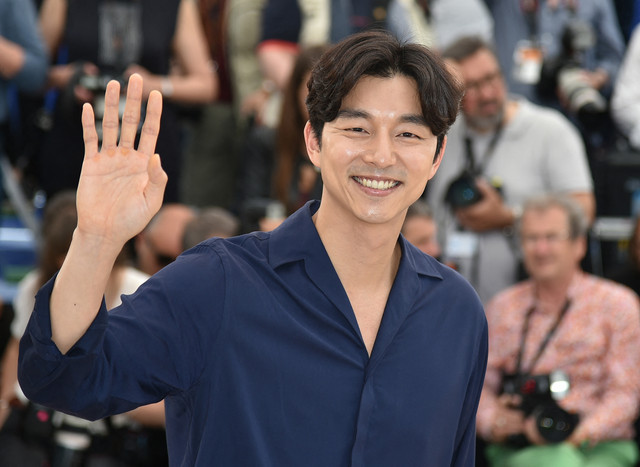 Aktor Korea Selatan Gong Yoo melambaikan tangan pada 14 Mei 2016 saat sesi foto untuk film "Bu-San-Haeng (Train to Busan)" di Festival Film Cannes ke-69 di Cannes, Prancis selatan. Foto: Alberto PIZZOLI / AFP