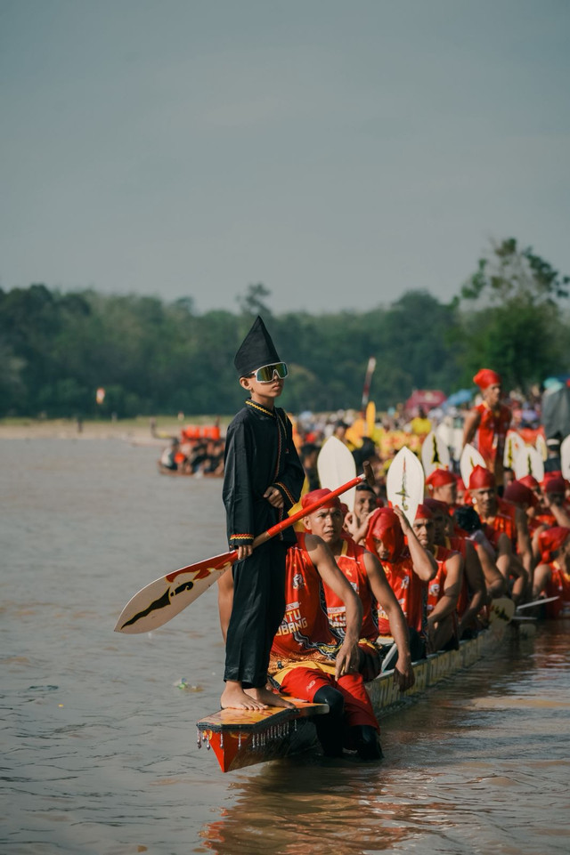 Gayuh alias joki kecil dari Tim Tuah Koghi Dubalang Ghajo — Rayyan, berdiri di ujung perahu dengan kacamata hitam khasnya. Penampilannya jadi sorotan karena disebut-sebut membawa “aura farming” ke level dewa. (Foto: Rihandro untuk Kamera Kuansing, 2025 — digunakan dengan izin)