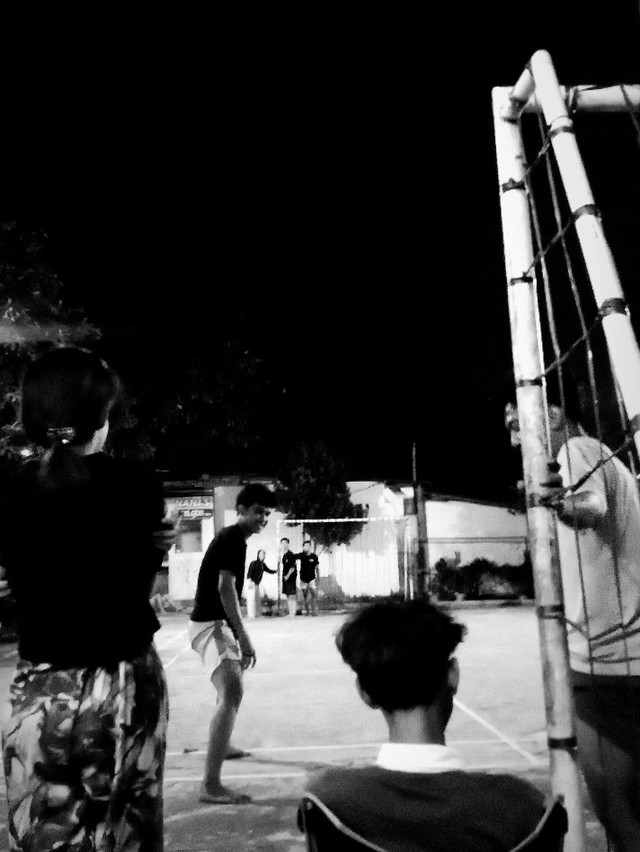 Anak muda bermain tabenteng di malam hari saat liburan