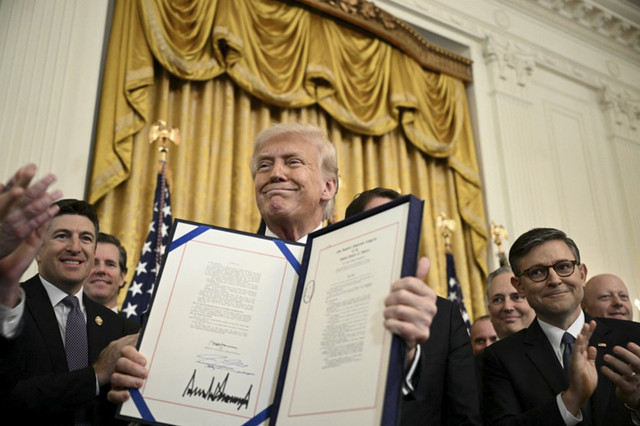 Presiden AS Donald Trump menampilkan Undang-Undang GENIUS (Mendu dan Menetapkan Inovasi Nasional untuk Undang-Undang Stablecoin AS) usai ditandangani di Ruang Timur Gedung Putih, Washington, DC, Amerika Serikat, Jumat (18/7/2025). Foto: Brendan Smialowski/AFP