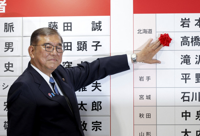 Shigeru Ishiba, Perdana Menteri Jepang dan presiden Partai Demokratik Liberal (LDP) yang berkuasa, meletakkan kertas merah di atas nama kandidat terpilih di markas besar LDP, pada hari pemilihan Majelis Tinggi, di Tokyo, Jepang, Minggu (20/7/2025). Foto: FRANCK ROBICHON/Pool via REUTERS