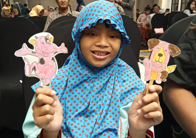 Seorang anak sedang bermain wayang kartun buatannya. Foto: Masruroh/Basra