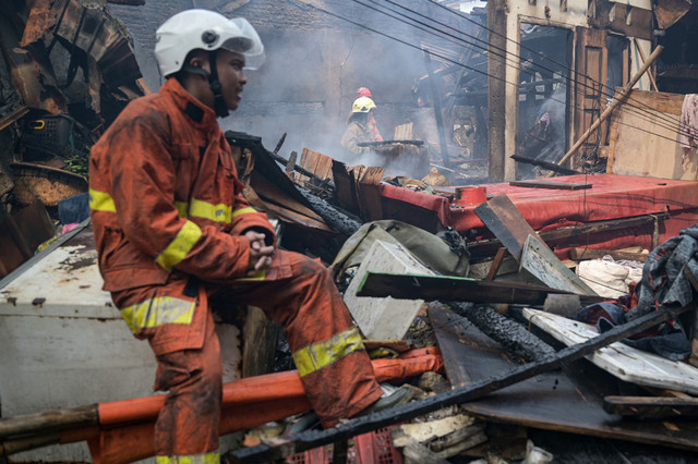 Petugas pemadam kebakaran melakukan pendinginan di lokasi kebakaran permukiman penduduk di Duri Utara, Tambora, Jakarta, Senin (21/7/2025). Foto: Fauzan/ANTARA FOTO