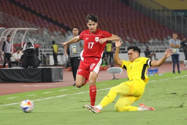 Pemain Timnas U-23 Indonesia Victor Dethan berebut bola dengan pemain Timnas U-23 Malaysia Muhammad Ubaidullah pada pertandingan Grup A Piala AFF U-23 2025 di Stadion Utama Gelora Bung Karno (SUGBK), Senayan, Jakarta, Senin (21/7/2025). Foto: Syawal Darisman/kumparan