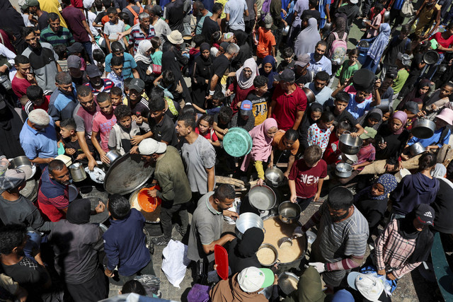 Warga Palestina berkumpul untuk menerima makanan dari dapur umum, di tengah krisis kelaparan, di Nuseirat, Jalur Gaza tengah, Senin (20/7/2025). Foto: Ramadan Abed/REUTERS