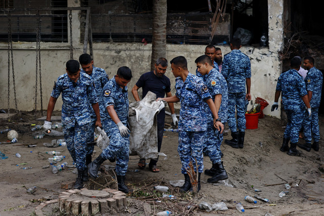 Anggota Angkatan Udara Bangladesh mengangkat puing pesawat di lokasi kejadian, setelah sebuah pesawat latih angkatan udara jatuh ke gedung milik kampus Milestone School and College, di Dhaka, Bangladesh, 22 Juli 2025. Foto: REUTERS/Mohammad Ponir Hossain