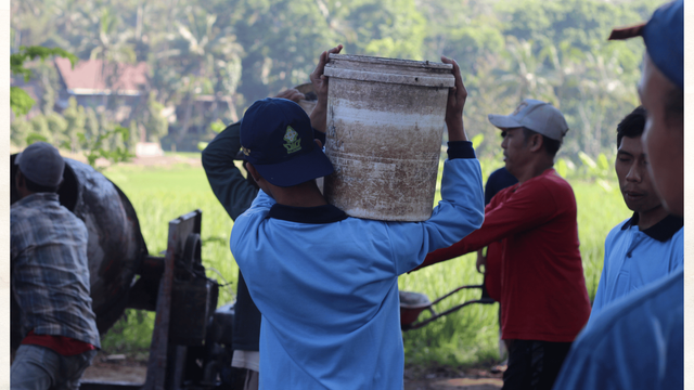 proses gotong royong mahasiswa KKN dan warga desa dalam pengecoran Jalan di Desa Krandon Lor.