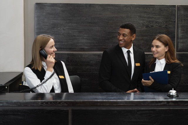 Sumber: Freepik.com (https://www.freepik.com/free-photo/receptionists-elegant-suits-work-hours_38661226.htm#fromView=search&page=1&position=16&uuid=6152d7e1-3e11-4f4d-9609-88138ffcf75e&query=Receptionist+hotel)