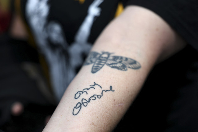 Seorang penggemar menunjukkan tato tanda tangan Ozzy Osbourne saat mengenang meninggalnya di bintang Ozzy Ousbourne di Walk of Fame Hollywood, Los Angeles Amerika Serikat, Selasa (22/7/2025). Foto: Patrick T. Fallon/AFP