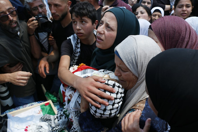 Seorang ibu memeluk jenazah anaknya yang syahid dalam konflik berkepanjangan di Palestina. Foto: Diana Khwaelid via Unsplash