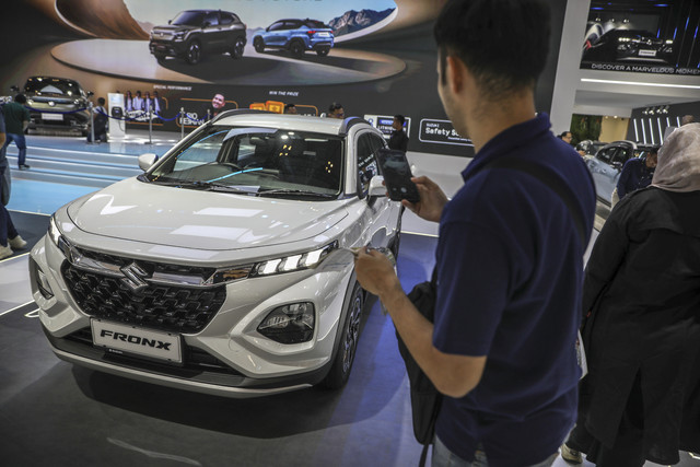 Calon pembeli memotret Mobil Fronx di booth Suzuki saat pergelaran pameran otomotif Gaikindo Indonesia International Auto Show (GIIAS) 2025 di ICE BSD, Tangerang, Kamis (24/7). Foto: Aditia Noviansyah/kumparan